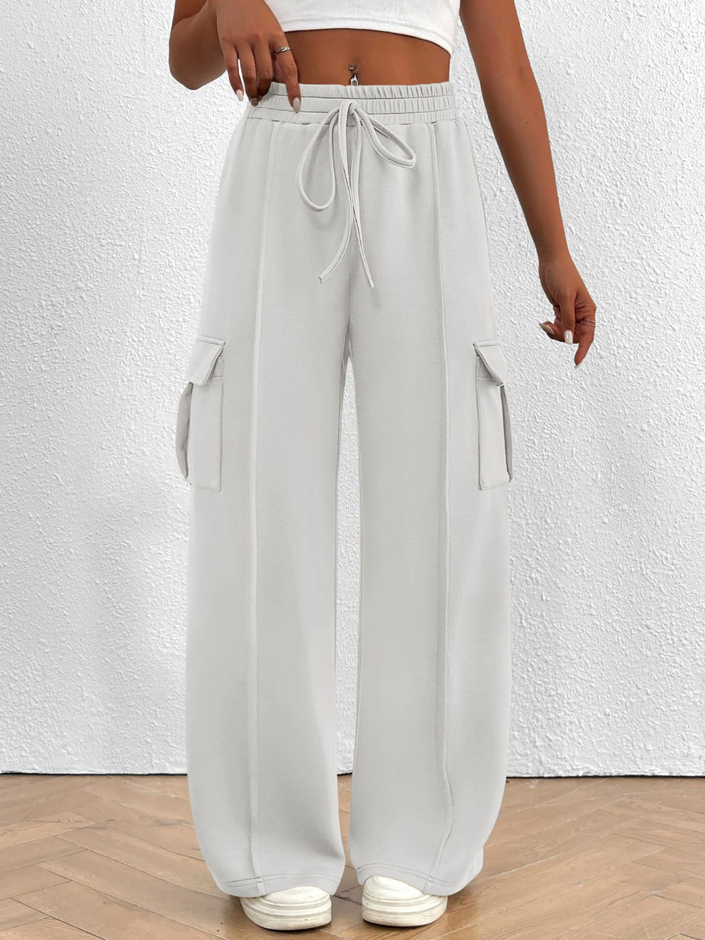 Light gray wide-leg pants with drawstring waist on a white background