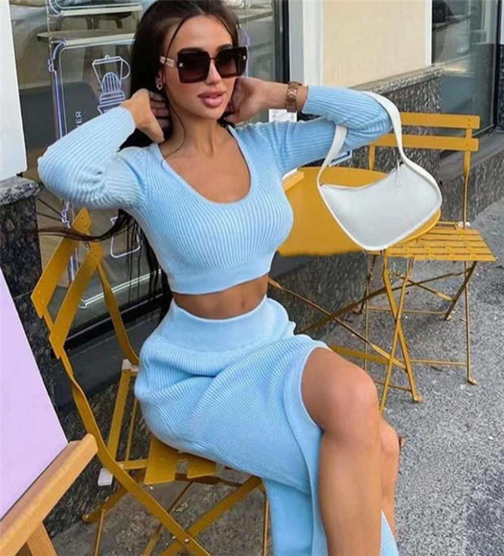 Woman in light blue ribbed long-sleeve crop top and high-slit midi skirt set, seated on yellow chair outdoors.