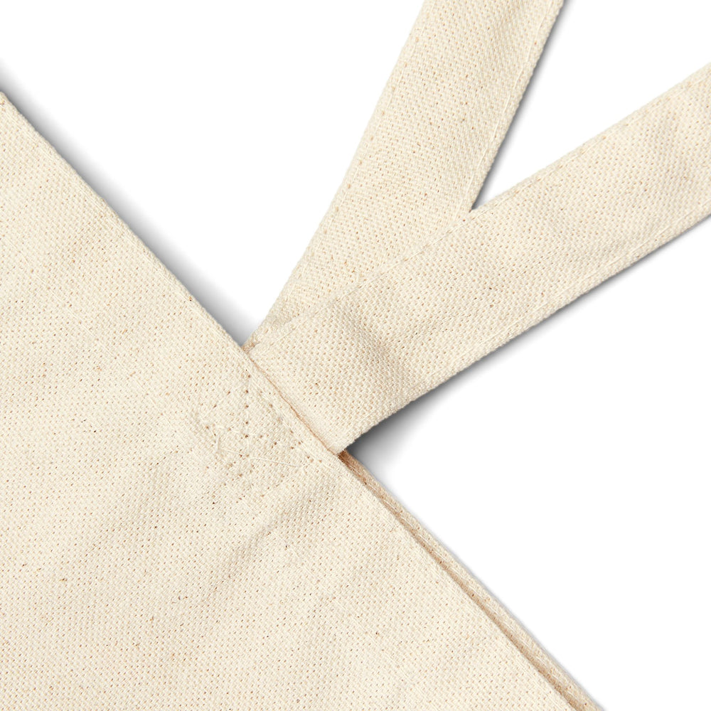 Close-up detail of reinforced stitching on natural canvas tote bag handle.