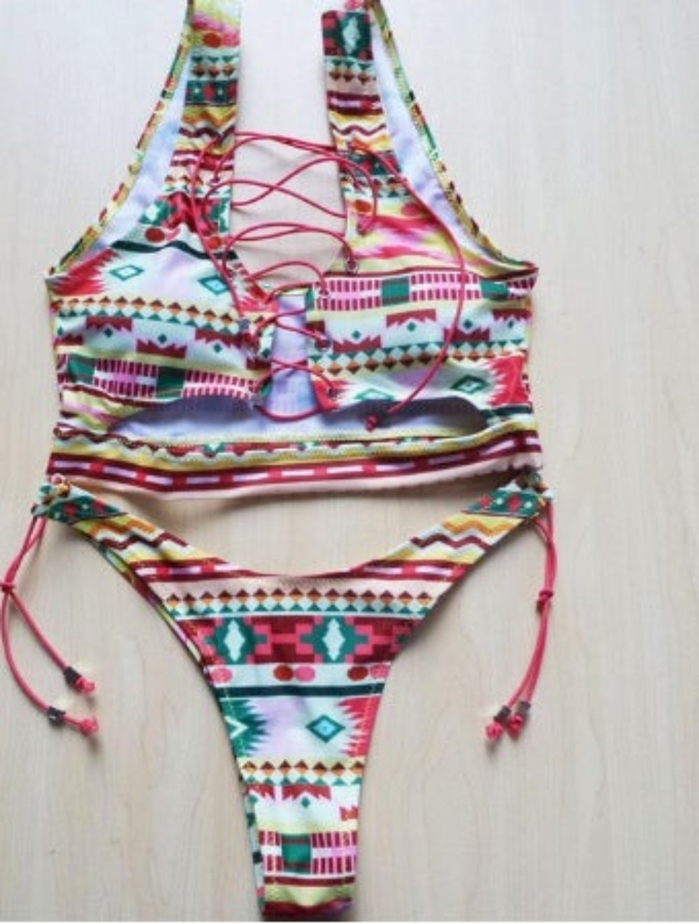 Ethnic print bikini set with lace-up halter top and tie-side bottom flat lay.