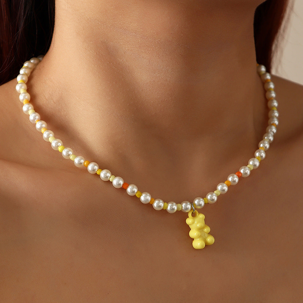 White yellow pearl gummy bear necklace on model – trendy colorful beaded choker with fun bear pendant, statement jewelry.