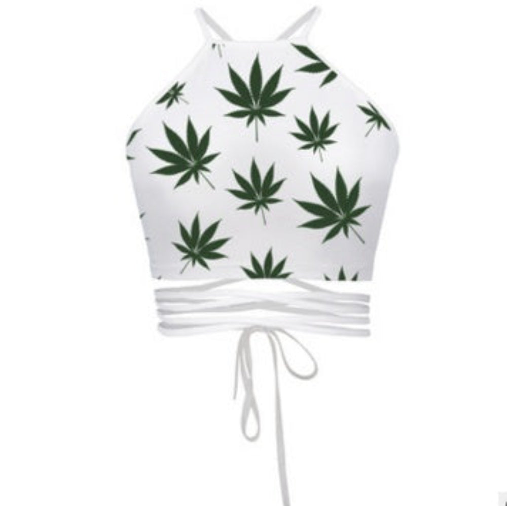 White cannabis leaf print halter crop top with multi-strap tie-back detail, shown flat lay on white background.