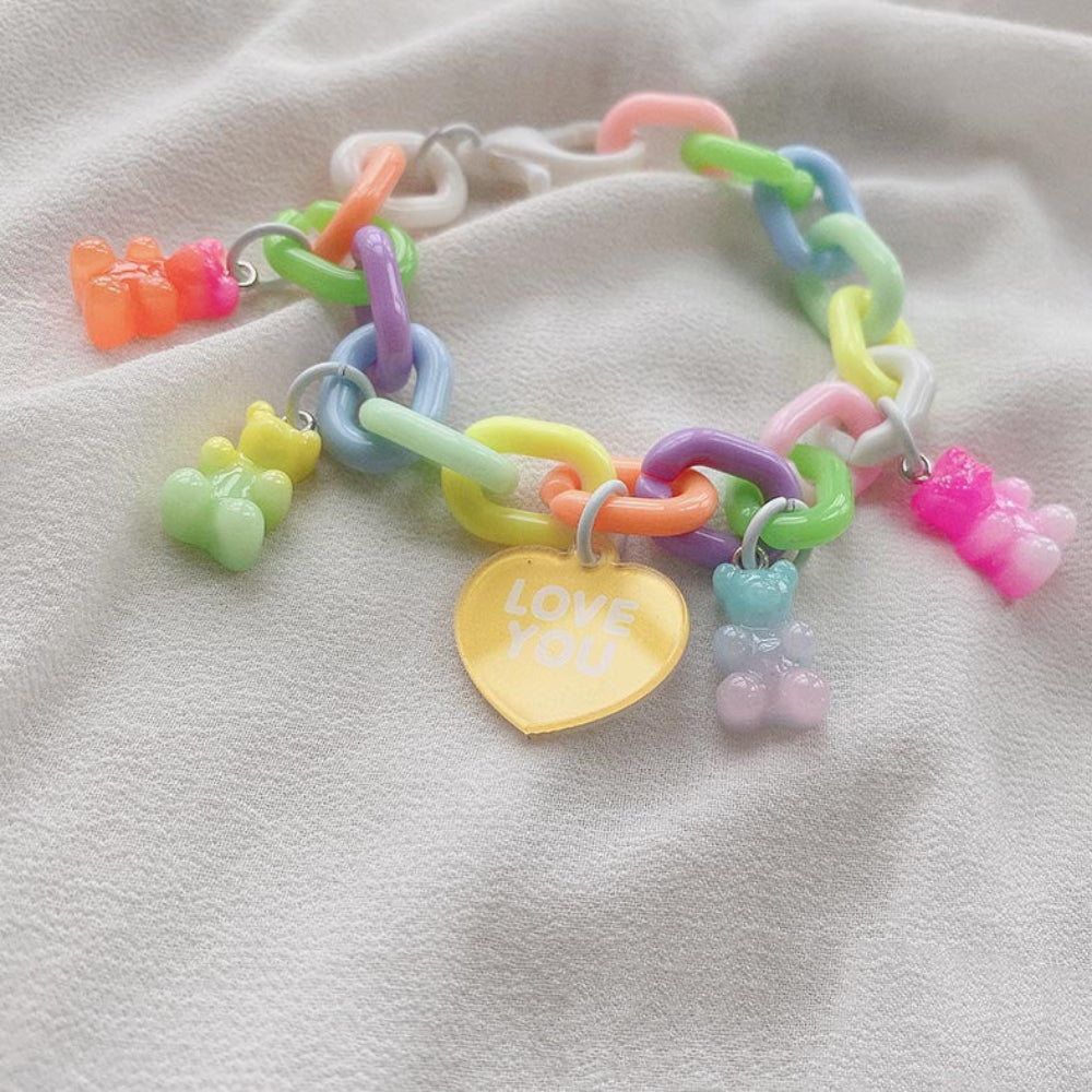 Vibrant multicolored gummy bear charm bracelet featuring oversized pastel chain links, multiple bright gummy bear charms, and a yellow heart charm that reads "LOVE YOU"