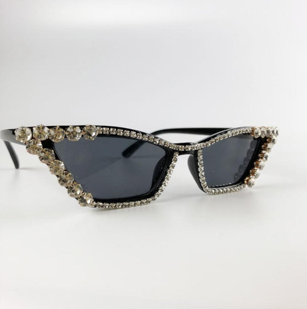 Black rhinestone cat-eye sunglasses with dark lenses and crystal trim, product photo on a white background.