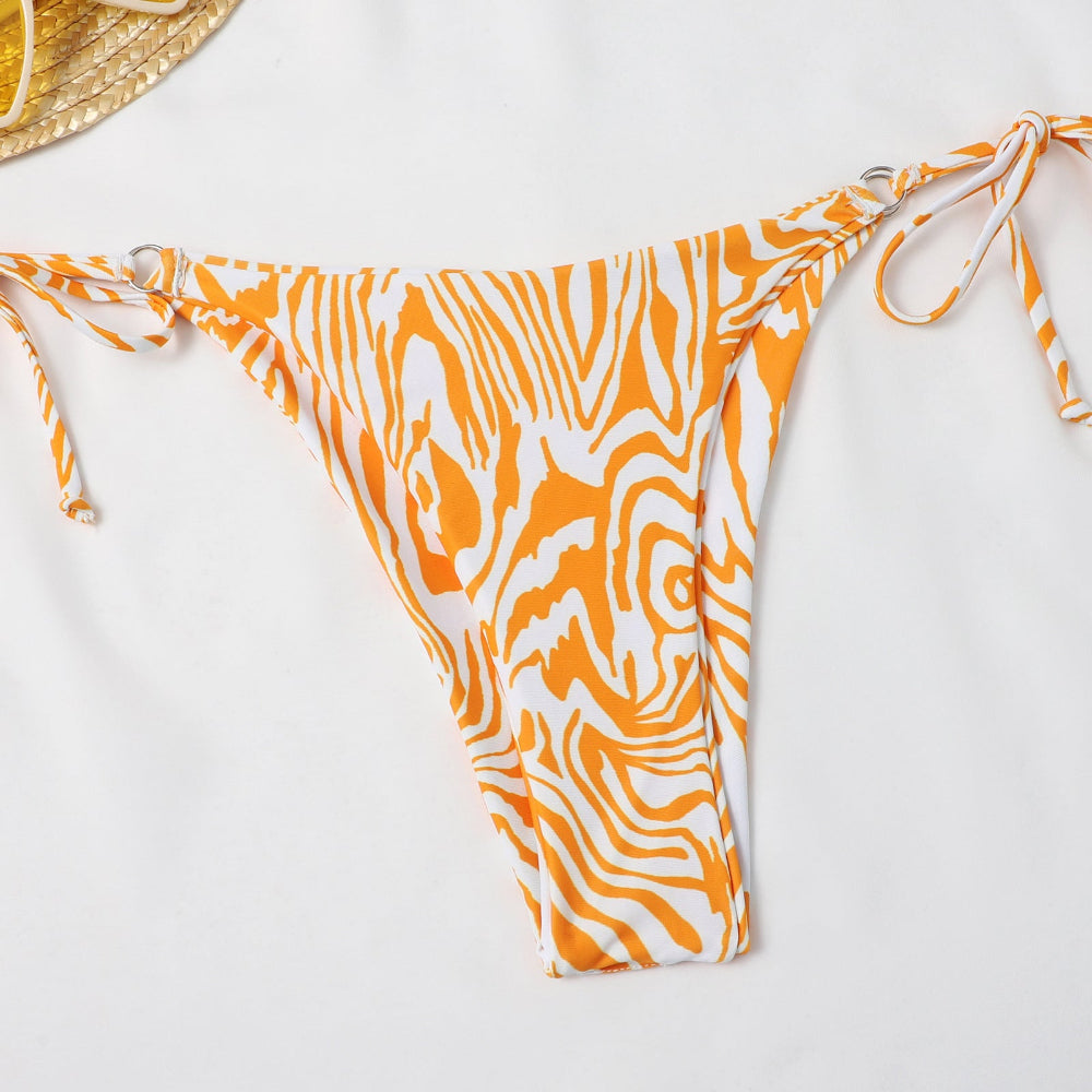 Orange and white patterned bikini bottom on a light gray background