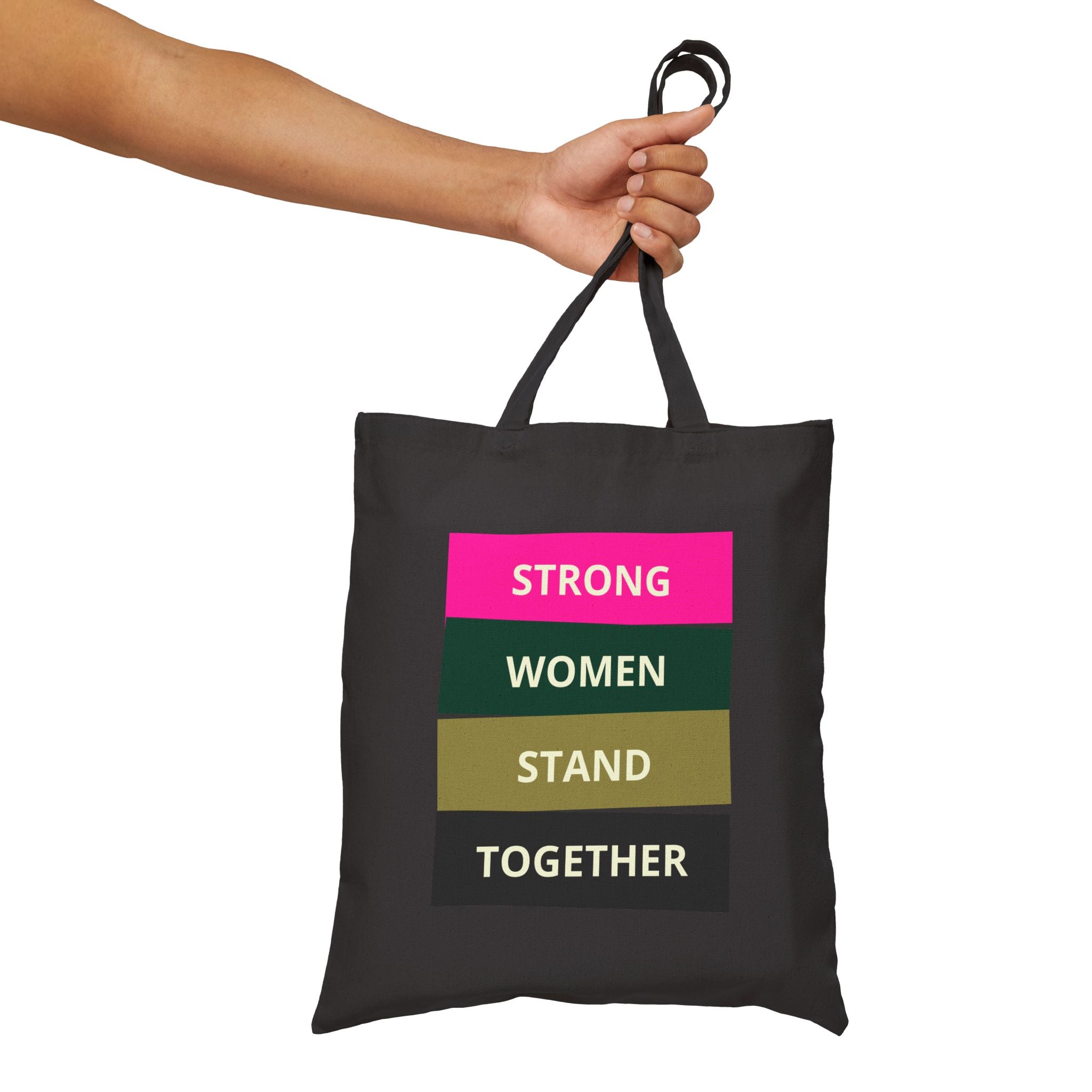 Black tote bag with motivational text held by a hand on a white background