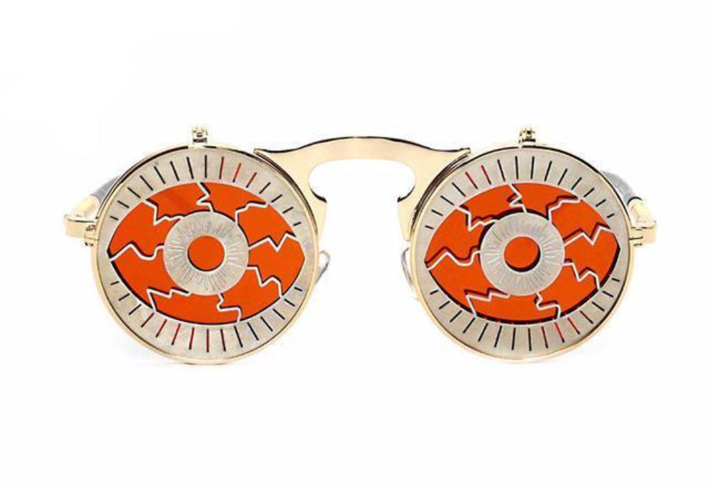 Gold flip-up steampunk sunglasses with orange cracked-iris eye covers, front product photo on a white background.