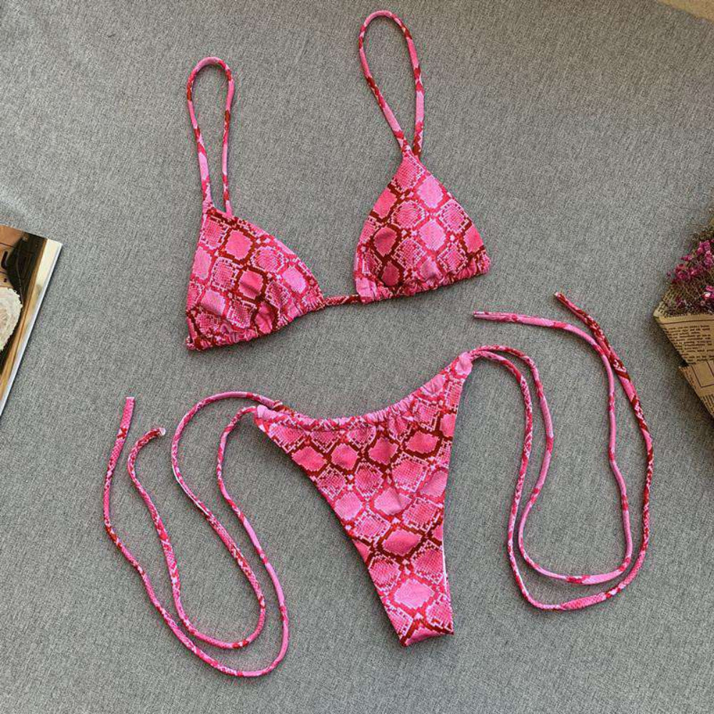 Pink bikini set with snake print on a gray surface