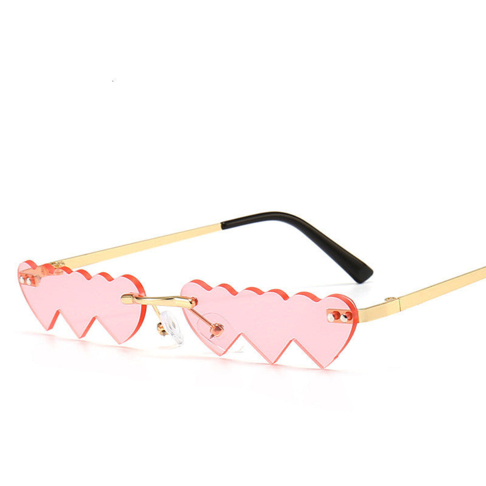 Rimless pink heart-shaped sunglasses with gold temples, product photo on a white background.