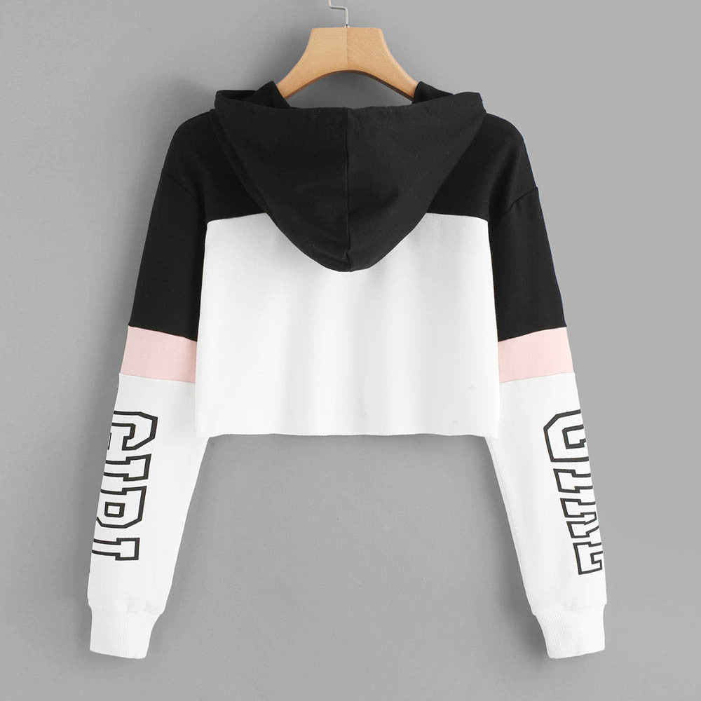 Black, white and pink colorblock cropped hoodie with "GIRL" graphic print on the sleeves, shown from the back on a wooden hanger.