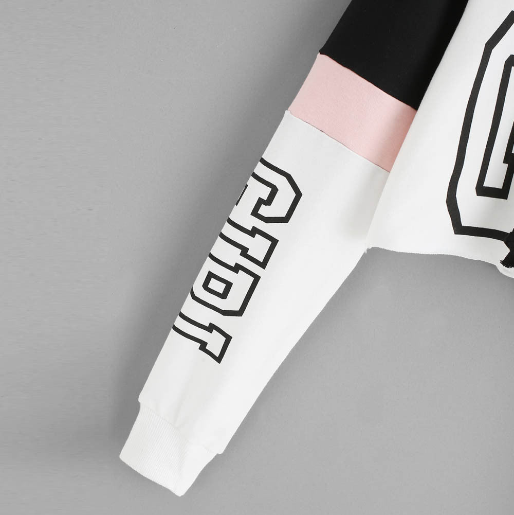 White sleeve with black "GIRL" graphic print and pink colorblock detail from a cropped hoodie, close-up view.