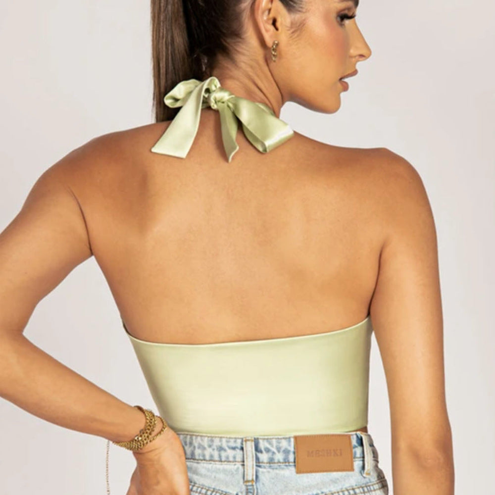 Sage green satin halter bandeau crop top with tie neck closure and open back, paired with denim jeans, shown from the back on a model.
