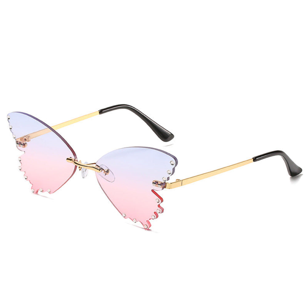 Rimless butterfly sunglasses with purple-to-pink gradient lenses, rhinestone edges, and gold temples, product photo on a white background.