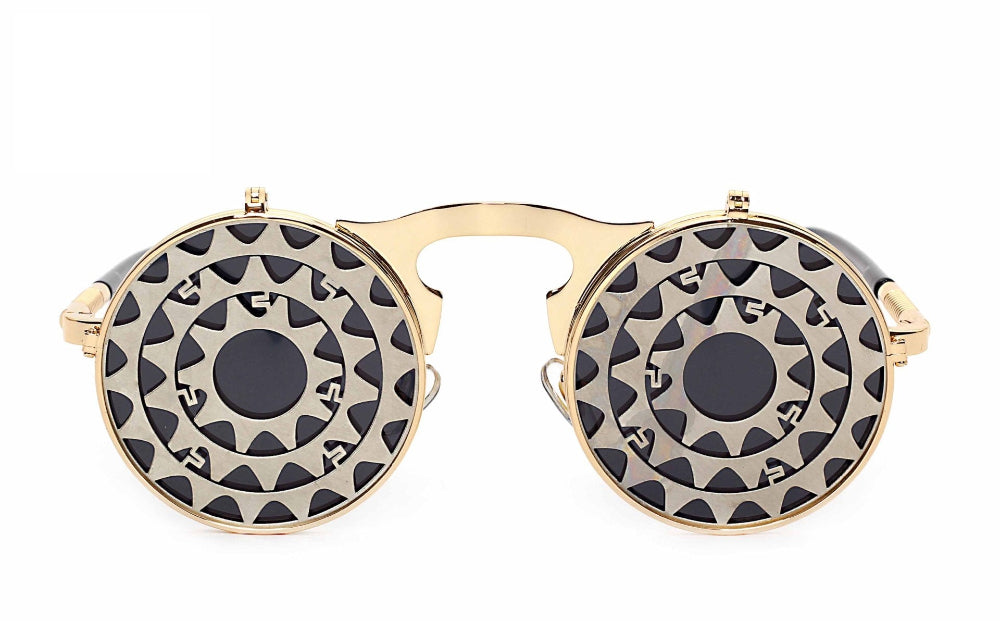 Gold flip-up steampunk sunglasses with concentric gear-cut covers over dark lenses, front product photo on a white background.