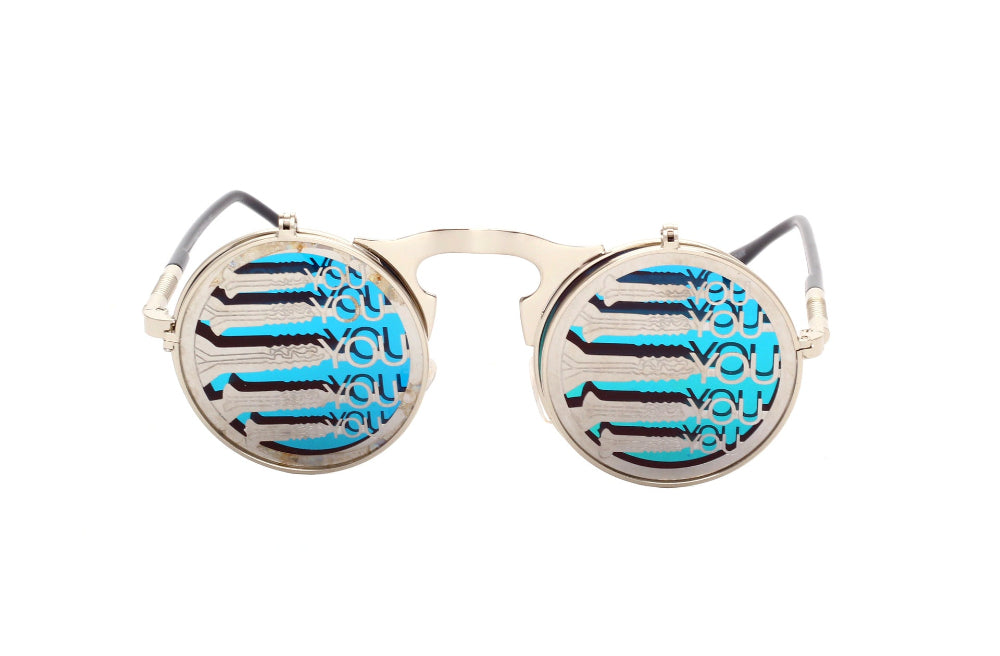 Silver flip-up steampunk sunglasses with round blue lenses printed with repeating “YOU” text and barcode stripes, front product photo on a white background.