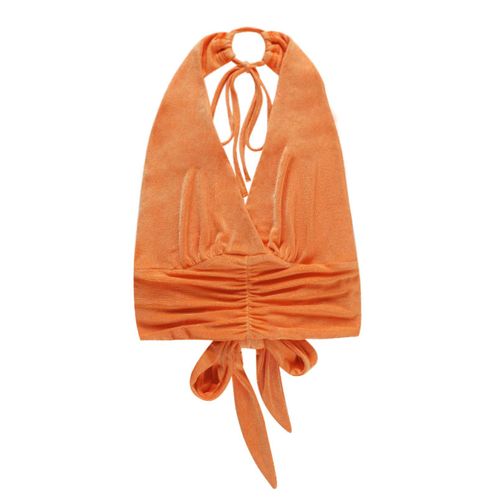 Orange velvet halter crop top with deep V-neck, ruched waistband, and tie closures at neck and hem, shown flat lay on white background.