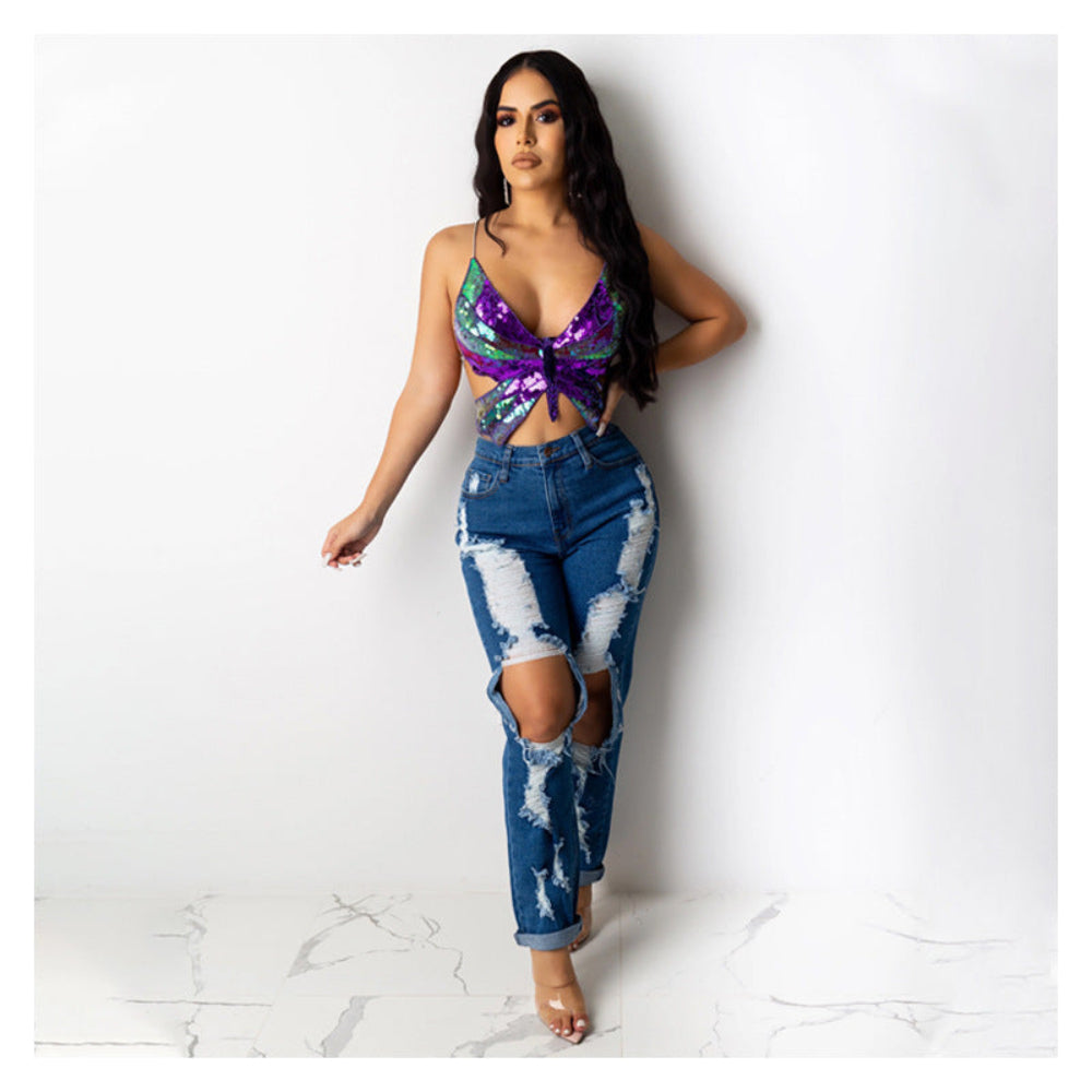 Purple and green sequin butterfly cut-out crop top paired with blue distressed ripped jeans, worn by a model.