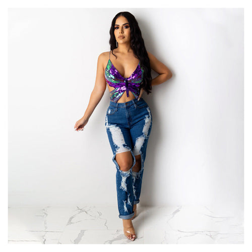 Purple and green sequin butterfly cut-out crop top paired with blue distressed ripped jeans, worn by a model.