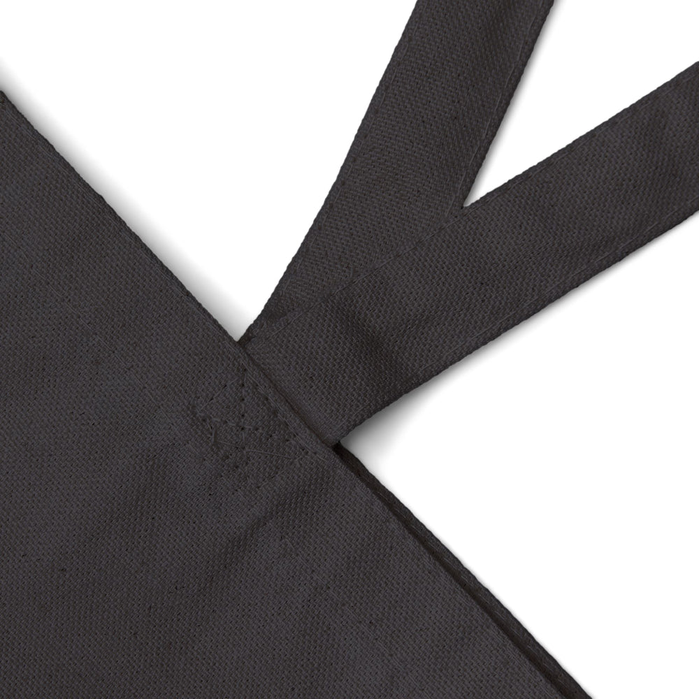 Close-up detail of reinforced stitching on black canvas tote bag handle.