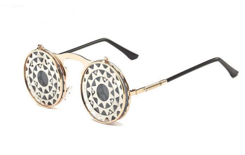 Gold flip-up steampunk sunglasses with round gear-cut covers over dark lenses and black temples, product photo on a white background.