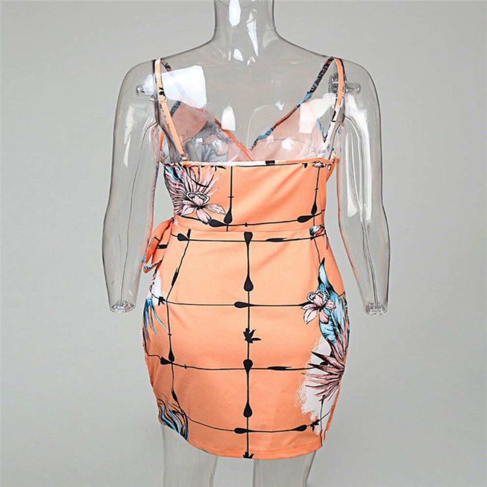 Peach tropical floral grid print mini dress on mannequin – trendy orange palm leaf bodycon dress with bow detail, studio gray background.