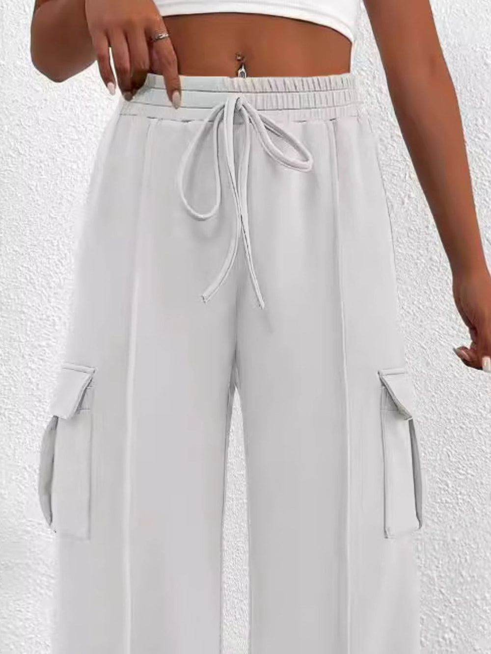 Light gray wide-leg pants with a drawstring waist on a white background