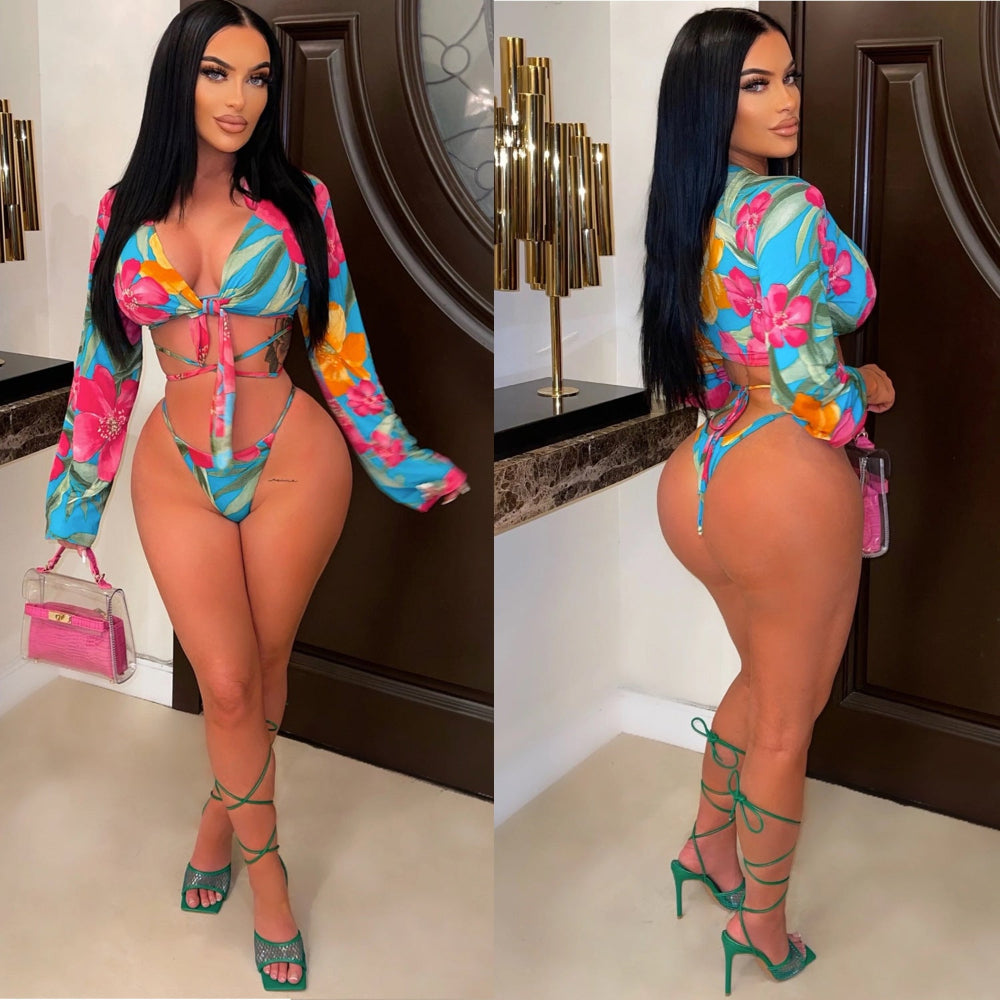 Woman in colorful outfit with floral pattern in a room with decorative elements.