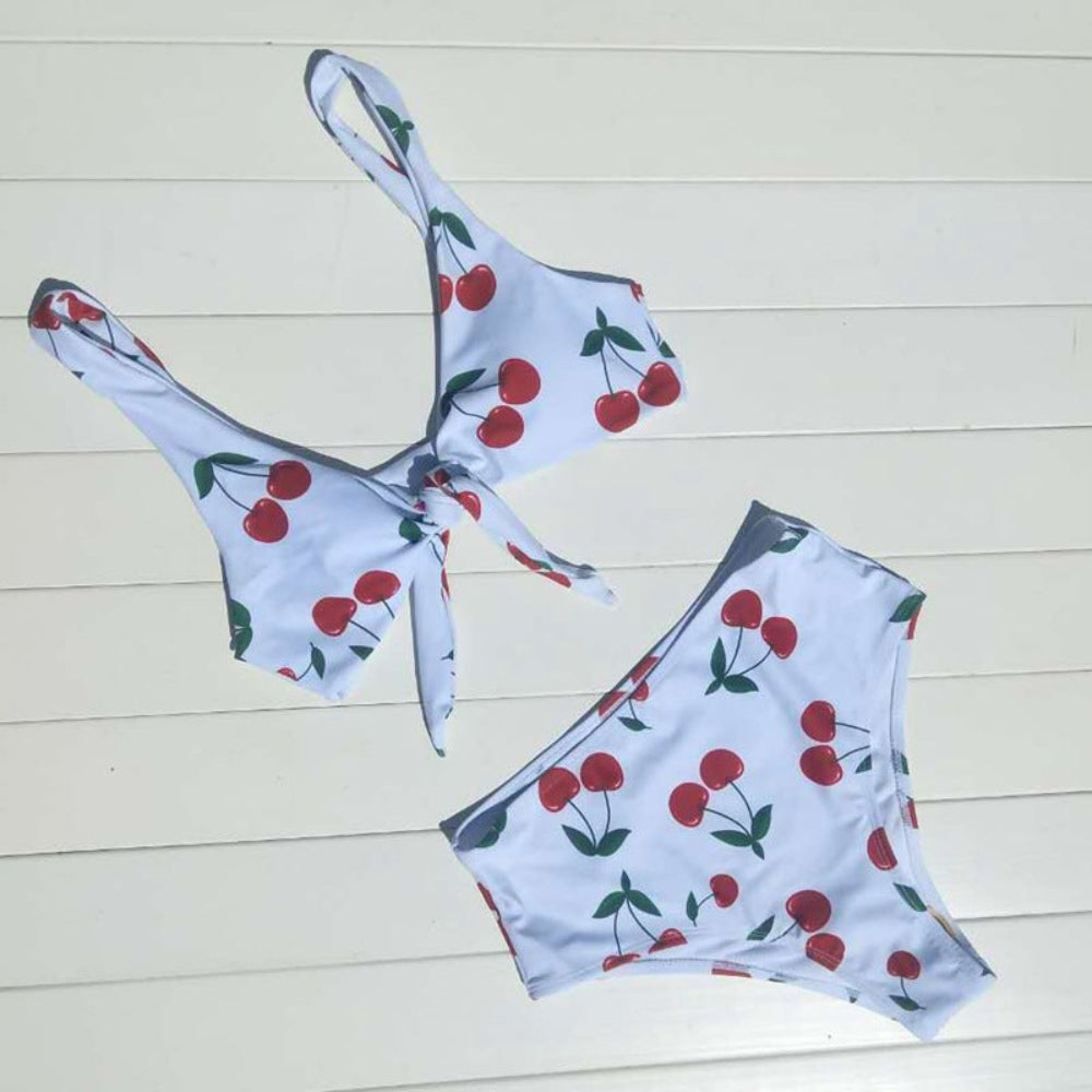 Bikini set with cherry pattern on a light wooden floor