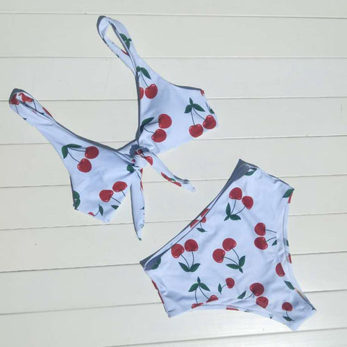 Bikini set with cherry pattern on a light wooden floor
