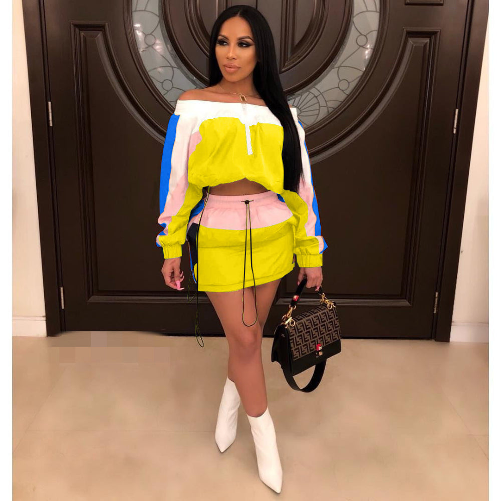 Woman in neon yellow, pink, and blue colorblock off-shoulder crop sweatshirt and matching mini skirt set with white boots, holding designer handbag.