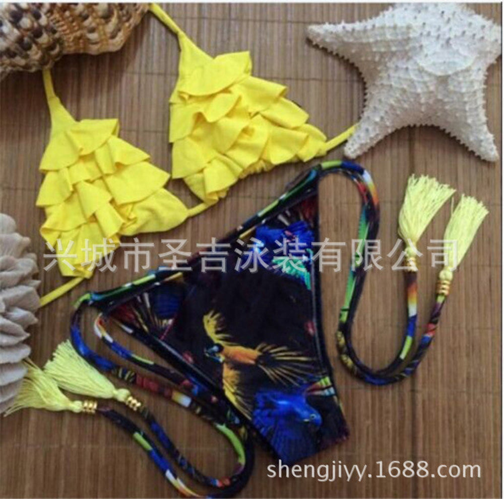 Yellow ruffled bikini top with colorful bird print tie-side bikini bottom with tassels flat lay.