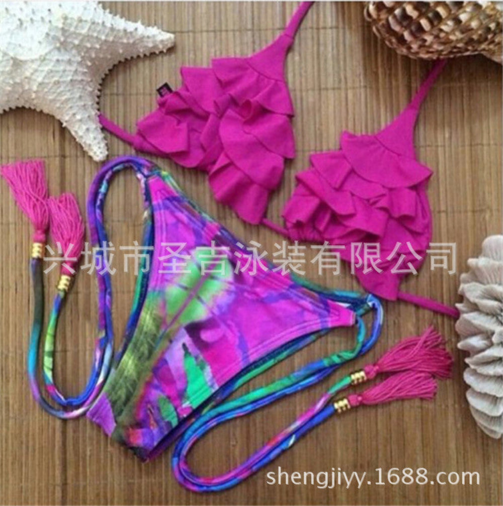 Magenta ruffled bikini top with colorful tie-dye tie-side bikini bottom with tassels flat lay.