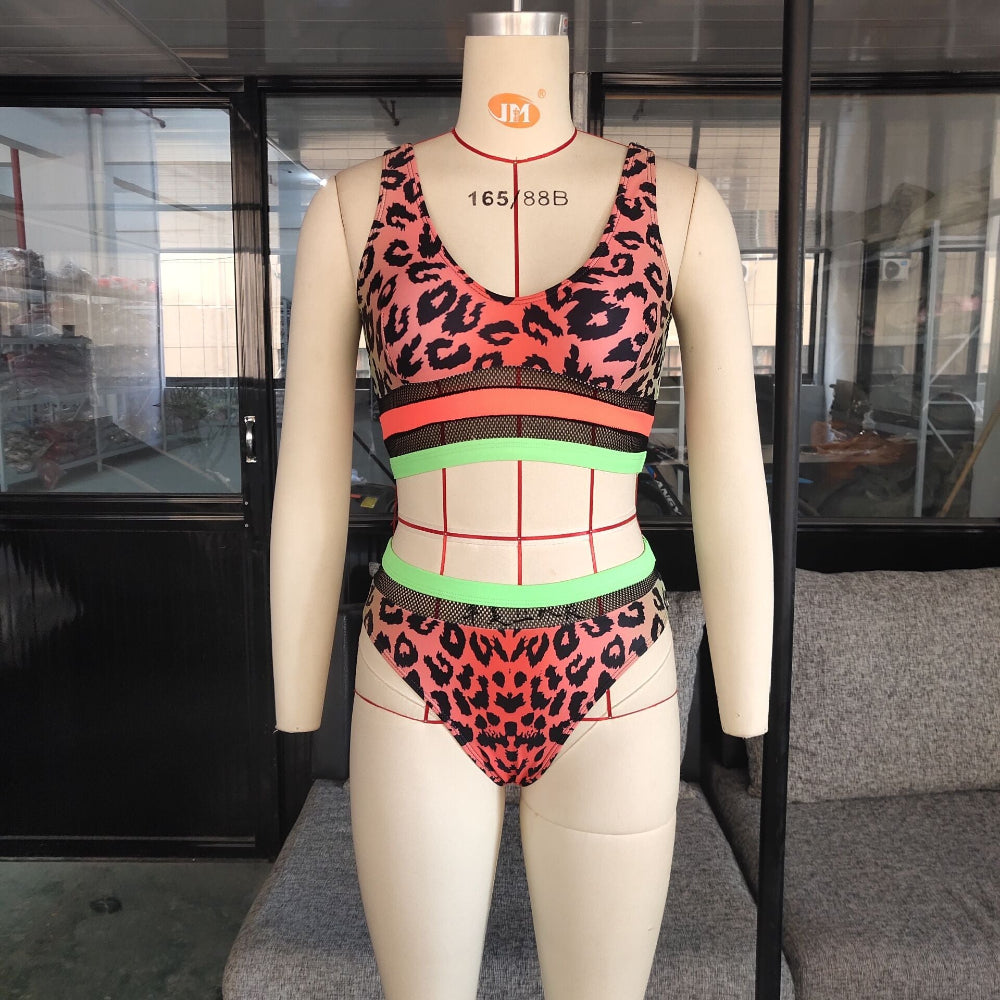 Leopard print bikini set with neon mesh panel and color block detail on mannequin.
