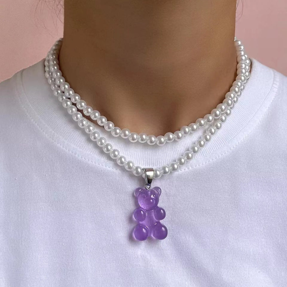 Pearl necklace with purple teddy bear pendant on model – trendy layered pearl choker with fun gummy bear charm, statement jewelry.