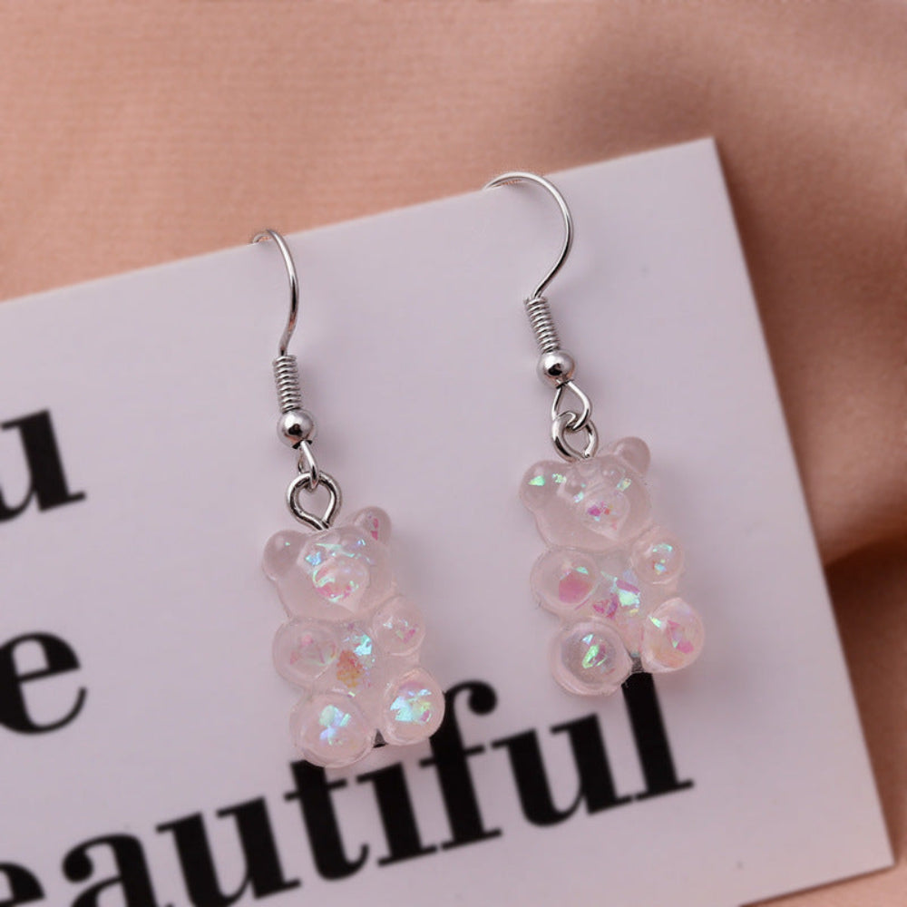 Translucent pink holographic gummy bear earrings with shimmering iridescent finish and silver fishhook ear wires