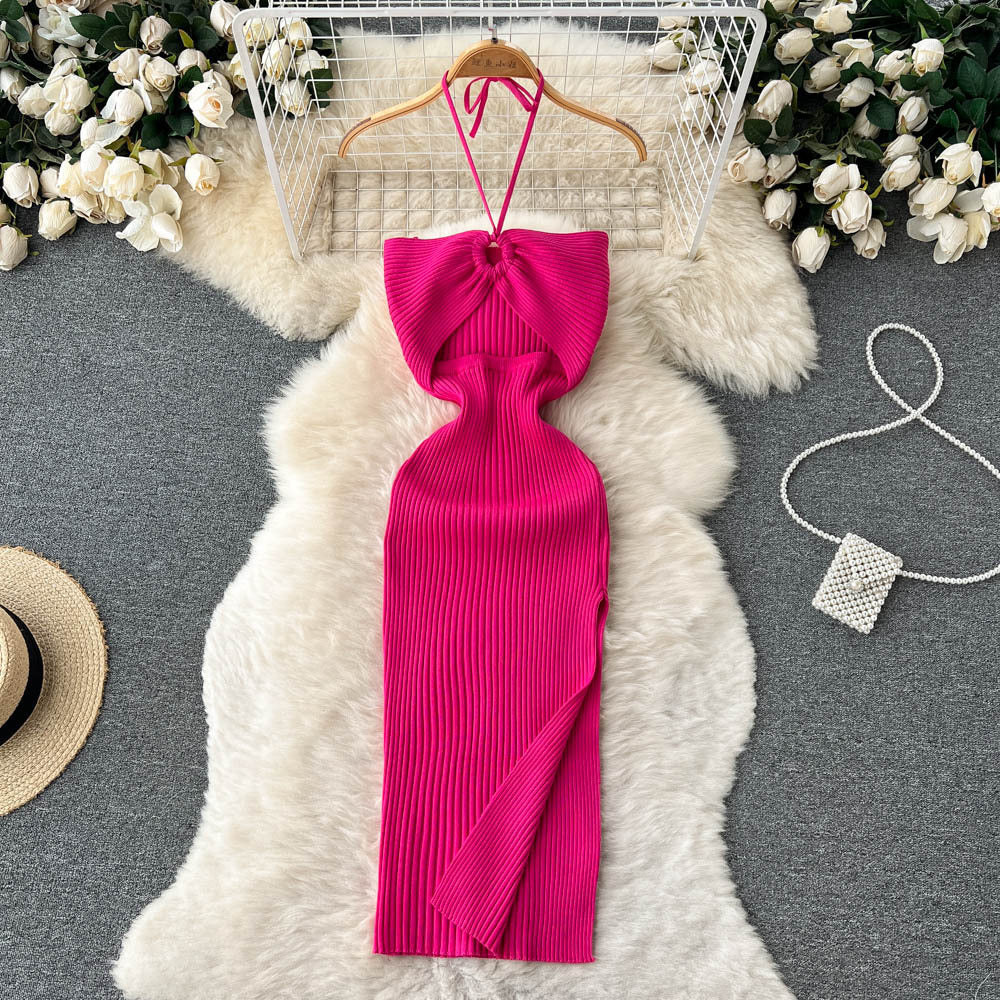 Hot pink ribbed knit halter maxi dress with front twist cutout detail on wooden hanger.