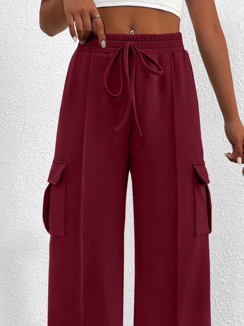 Maroon cargo pants worn by a person on a white background