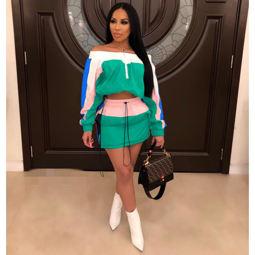 Woman in green, pink, and blue colorblock off-shoulder crop sweatshirt and green mini skirt set with white boots, holding designer handbag.