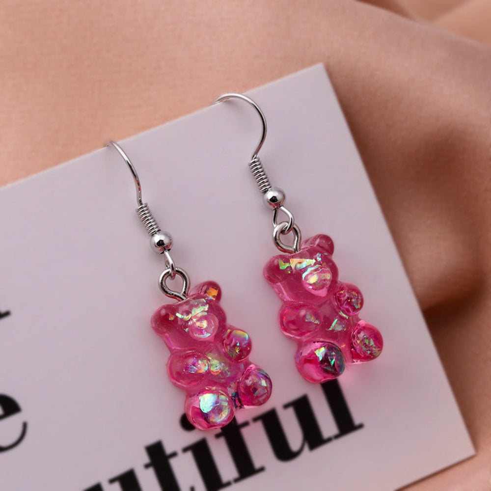 Pair of pink iridescent gummy bear earrings with holographic sparkle and silver fish hook ear wires