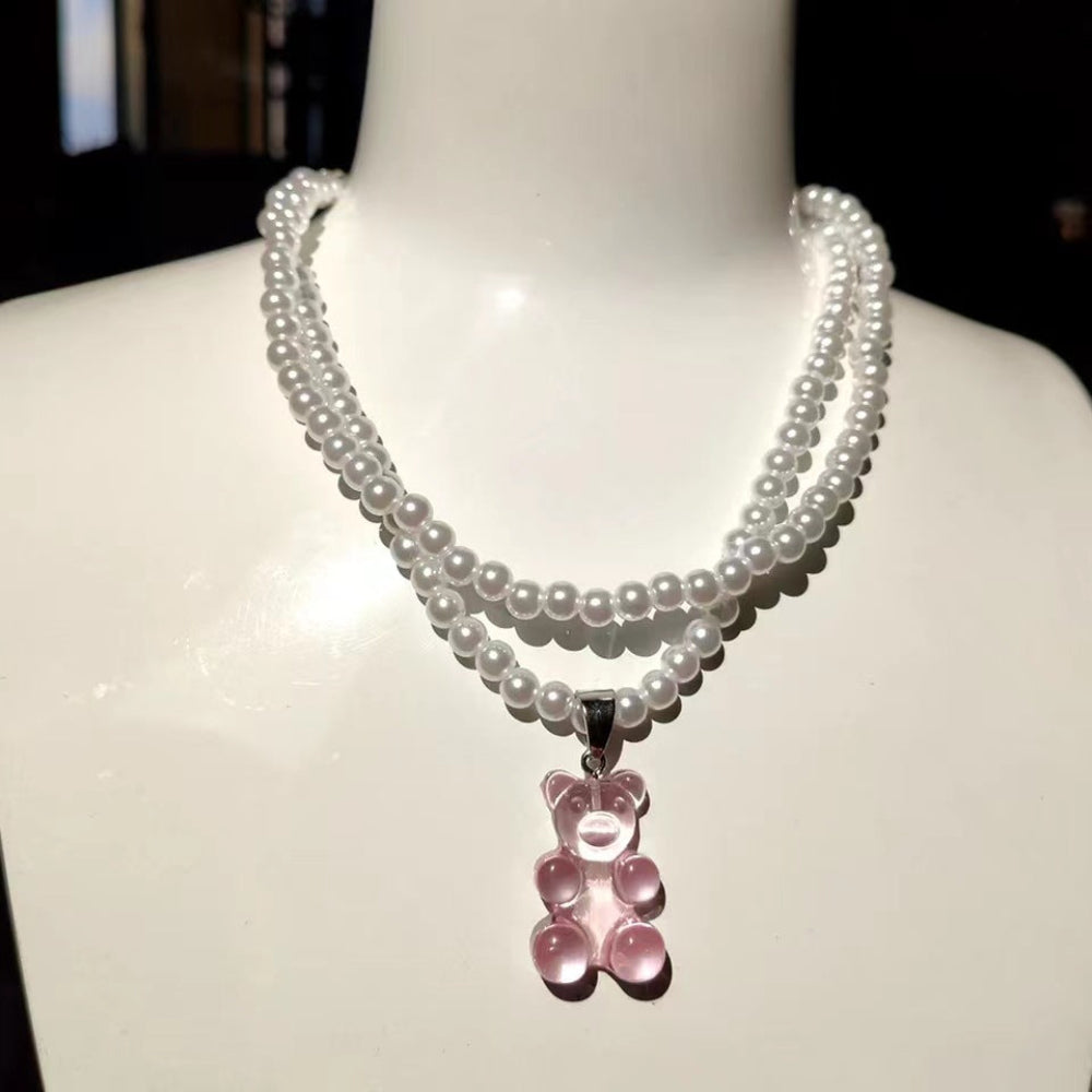 Pearl necklace with pink teddy bear pendant on mannequin – trendy layered pearl choker with fun gummy bear charm, statement jewelry.