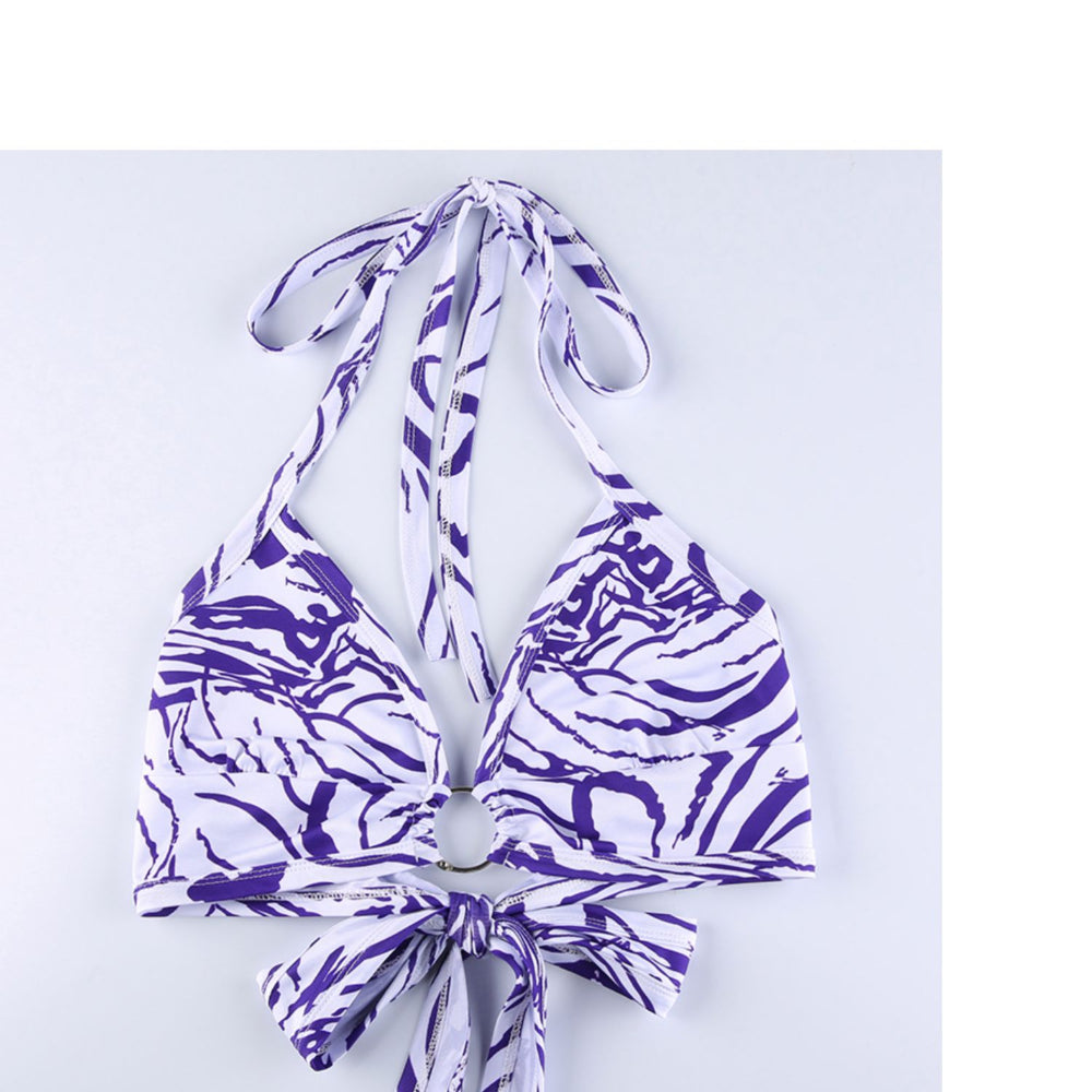 Purple and white patterned bikini top on a light blue background