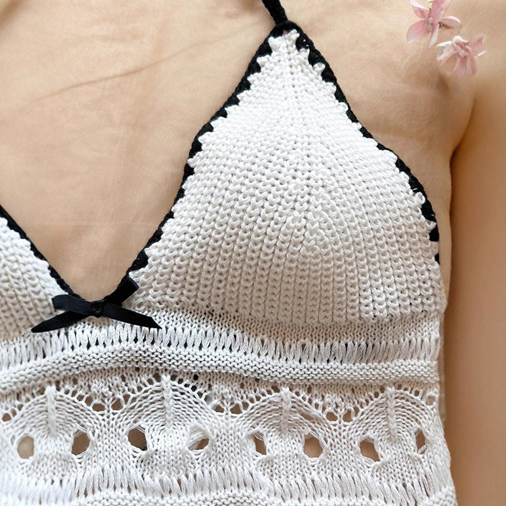 Close-up of white crochet halter crop top with black trim and small black bow detail on model.