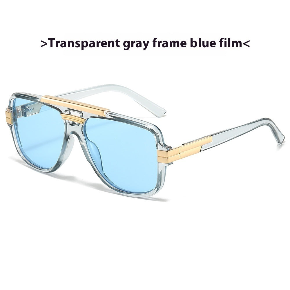 Transparent gray square retro sunglasses with gold brow bar and light blue lenses, product photo on a white background.