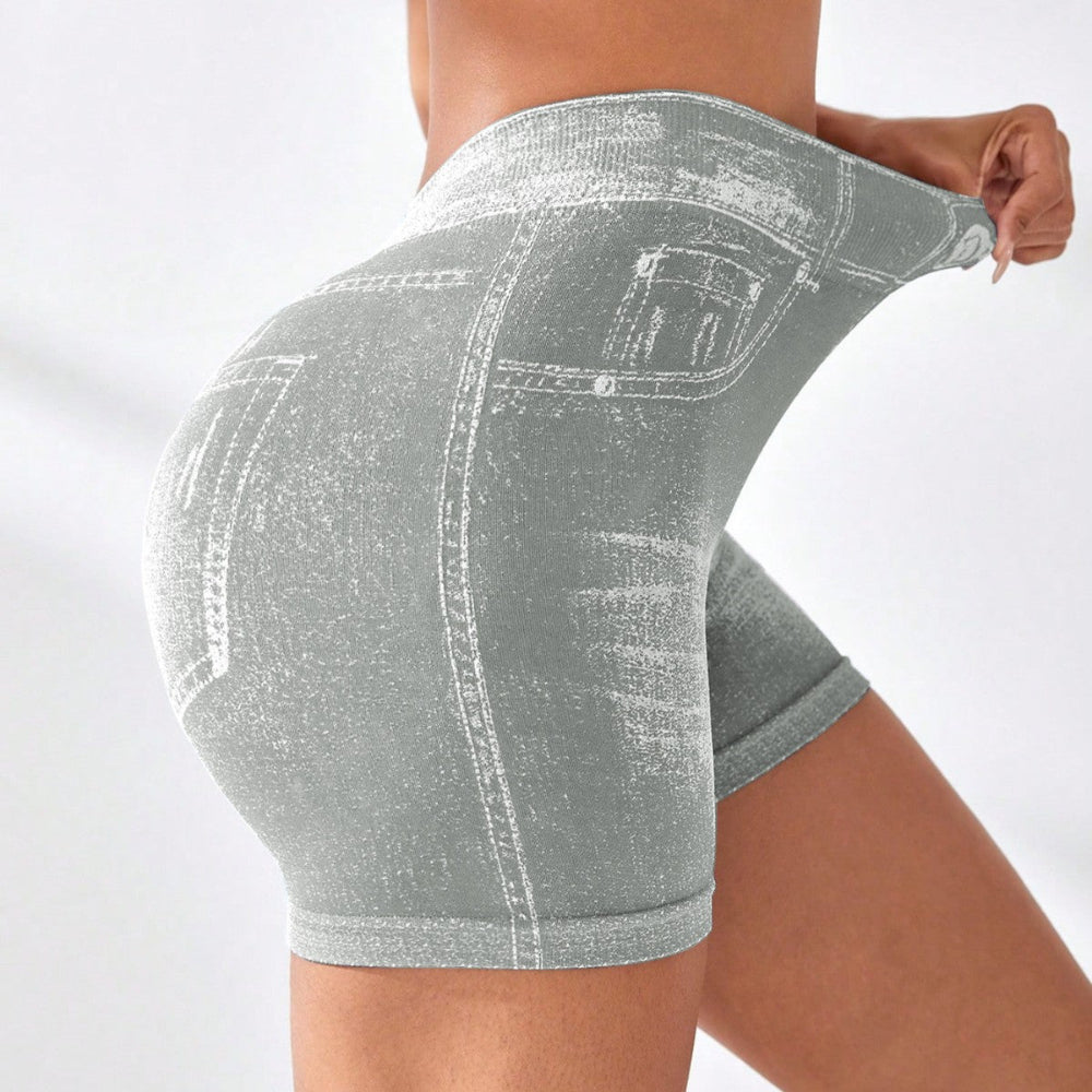 Woman modeling light gray denim-style high-waisted stretch shorts with back pockets and white contrast stitching, shown from a rear three-quarter view while adjusting the waistband against a clean white studio background.