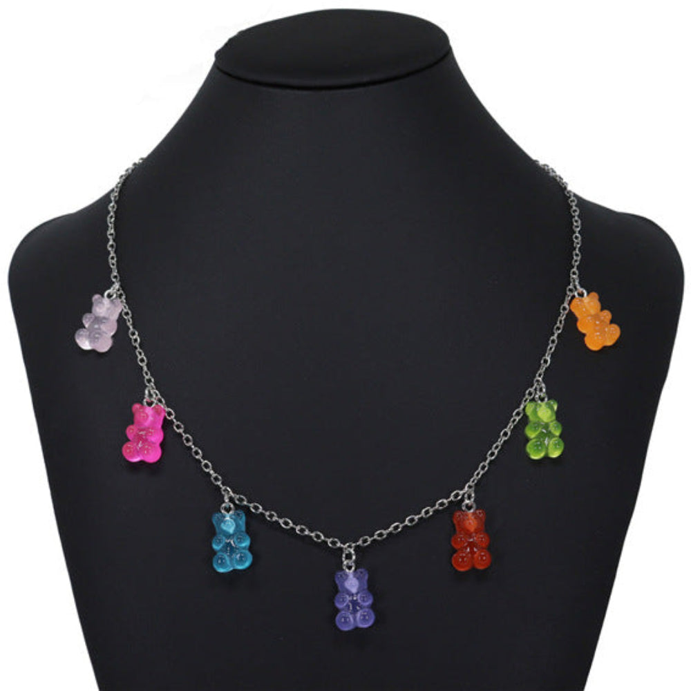 Silver curb chain necklace featuring six dangling translucent gummy bear charms in vibrant colors: purple, pink, blue, orange, green, and red. Fun, bold statement choker-style necklace displayed on a black mannequin bust.