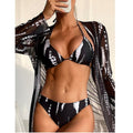 Model in black white tie-dye bikini with matching sheer kimono cover-up taking selfie