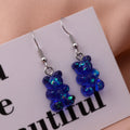 Translucent blue holographic gummy bear earrings with shimmering iridescent sparkle and silver fishhook ear wires