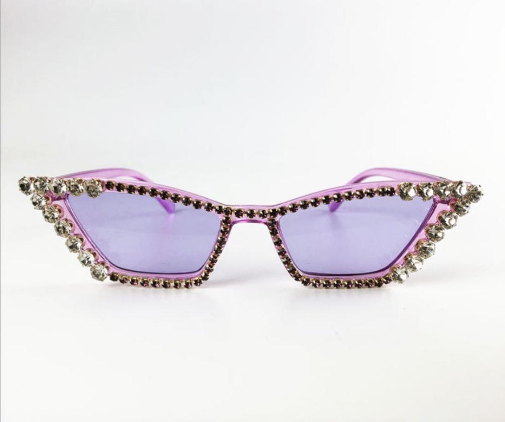 Purple cat-eye sunglasses with lilac lenses and crystal rhinestone trim, product photo on a white background.