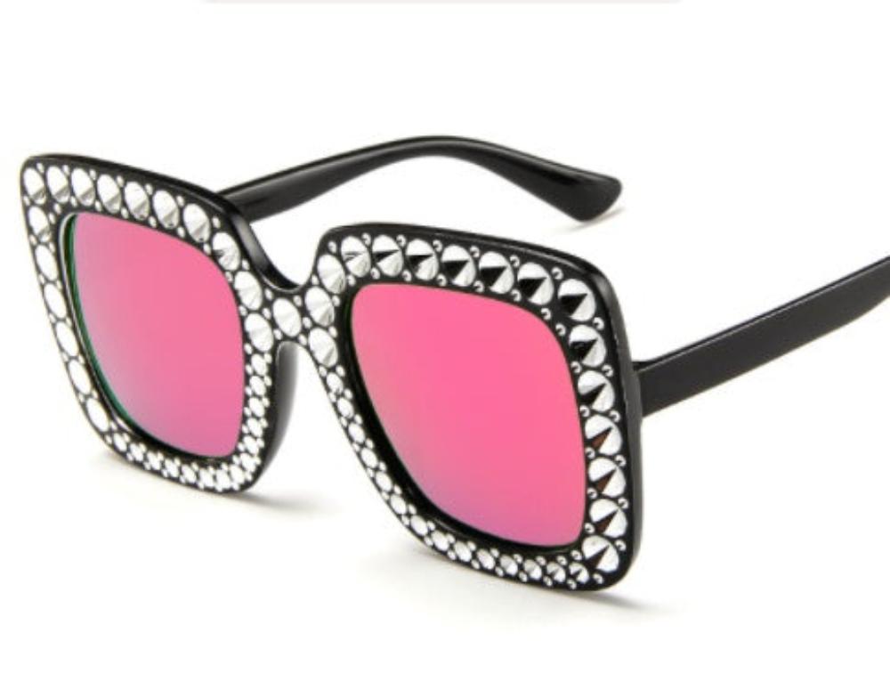 Black oversized square sunglasses with pink lenses and crystal-studded frames, product photo on a white background.