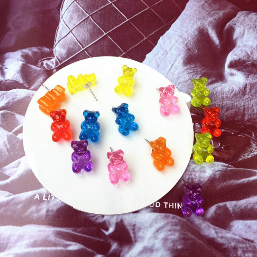 Assorted translucent rainbow gummy bear hair clips in bright colors including red, orange, yellow, blue, purple, pink and green, displayed on white round tray